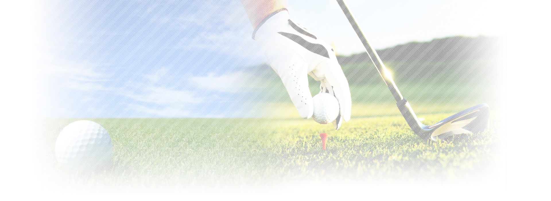 golfer holding golf ball while placing it on tee